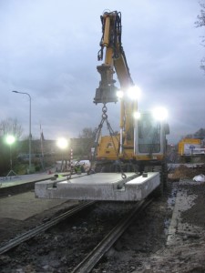 Foto: de eerste raildraagplaat voor de overweg in spoor 101 hangt klaar in de kraan.